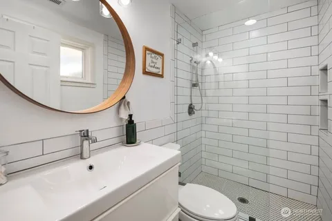 a bathroom with a sink mirror toilet and shower
