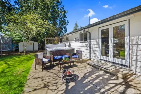 a view of a patio with table and chairs potted plants and a large tree