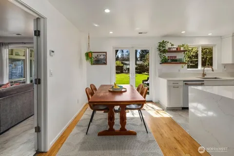 a view of a kitchen with kitchen island a table and chairs in it