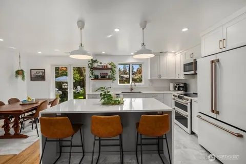 a kitchen with granite countertop counter space dining table and stainless steel appliances