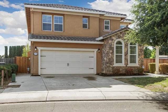 a front view of a house with a yard and a garage