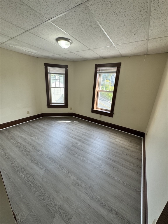 175 Maple Street, Unit 4R Springfield, MA 01105 - Photo 5 of 10 an empty room with wooden floor and windows