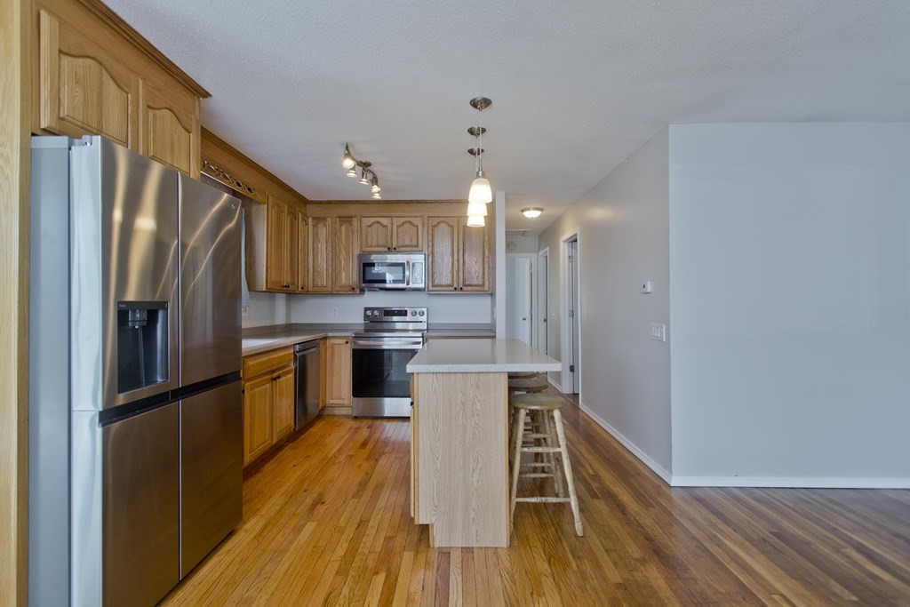 61 Arbor Road Enfield, CT 06082 - Photo 11 of 39 a kitchen with kitchen island wooden floors appliances and cabinets