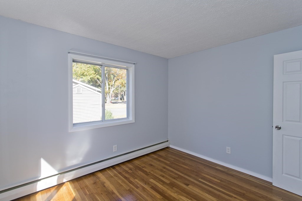 61 Arbor Road Enfield, CT 06082 - Photo 20 of 39 a view of an empty room with wooden floor and a window