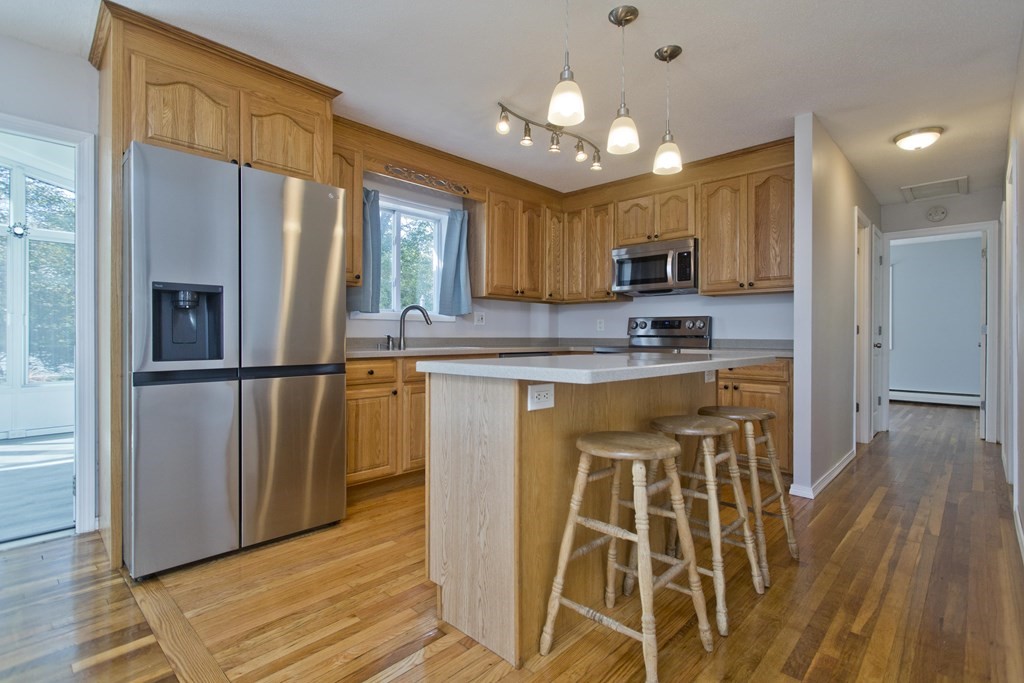 61 Arbor Road Enfield, CT 06082 - Photo 10 of 39 a kitchen with stainless steel appliances granite countertop a refrigerator a stove a sink and a microwave oven with wooden floor