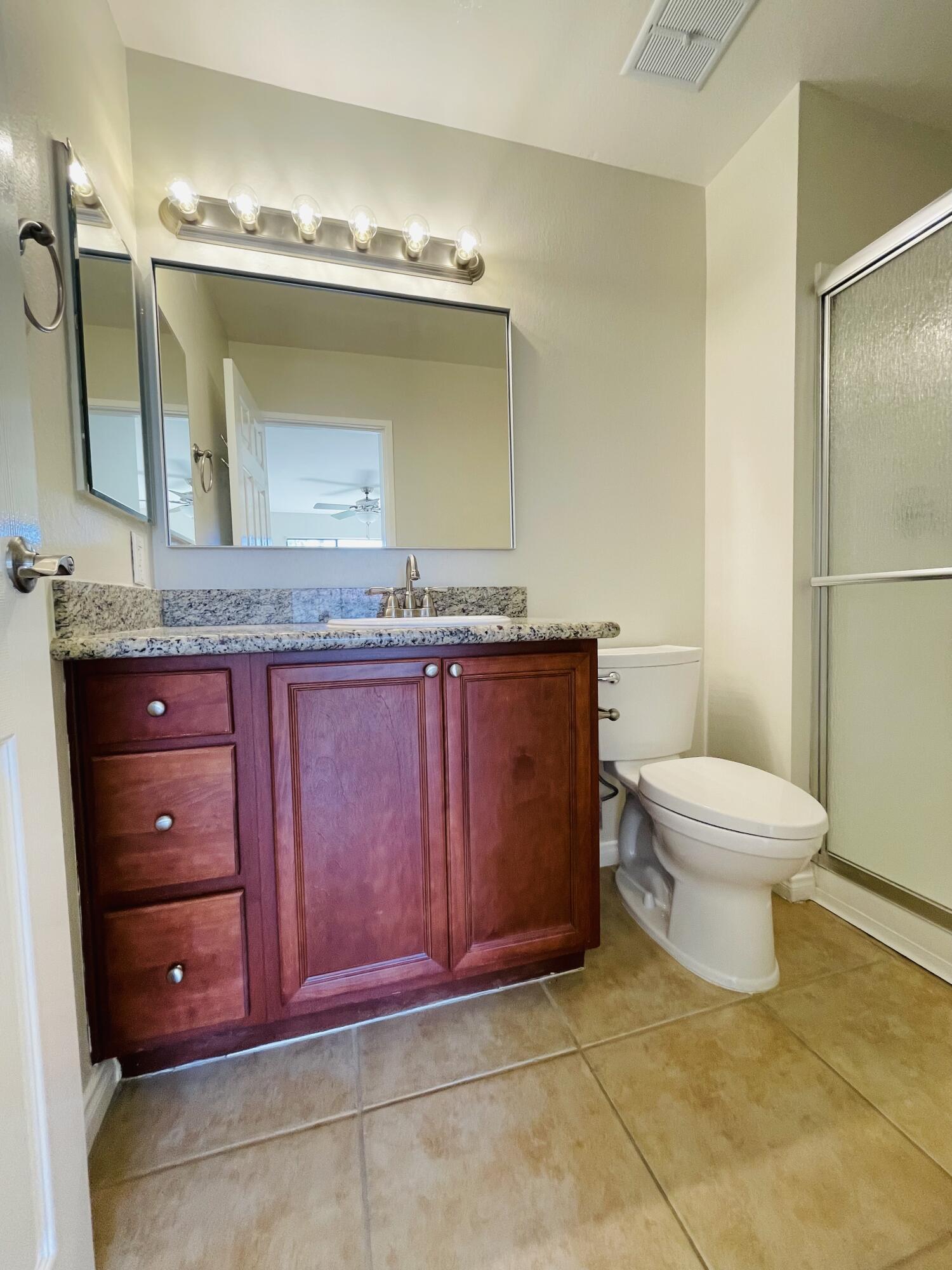 43376 Cook Street, Unit 38 Palm Desert, CA 92211 - Photo 11 of 33 a bathroom with a granite countertop toilet sink and mirror