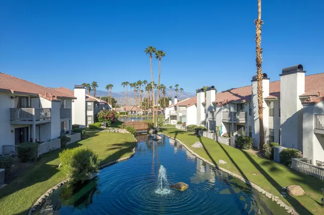a balcony with table and chairs potted plants