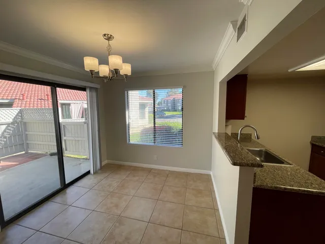 a room with chandelier fan and windows