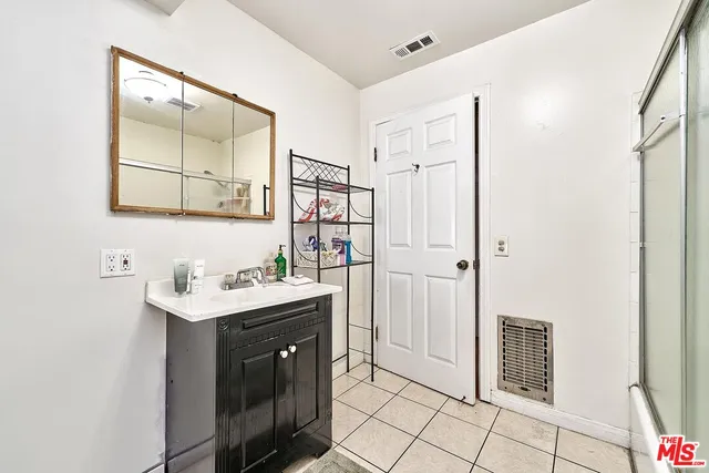 a bathroom with a sink a mirror a vanity and a shower