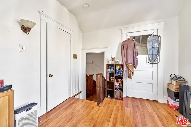 a view of a bedroom with wooden floor and furniture