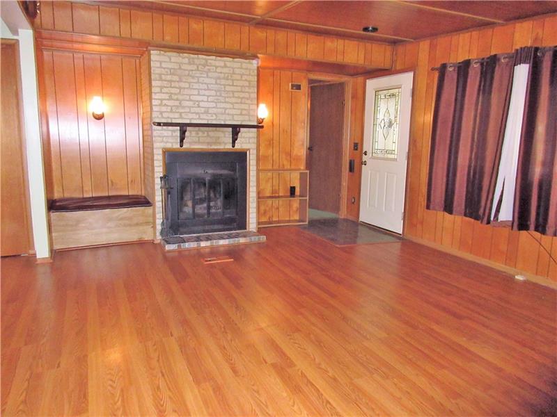 1000 Winfield Road Cabot, PA 16023 - Photo 3 of 24 Get cozy by the wood burning fireplace in this family room that is open to the kitchen and dining room!