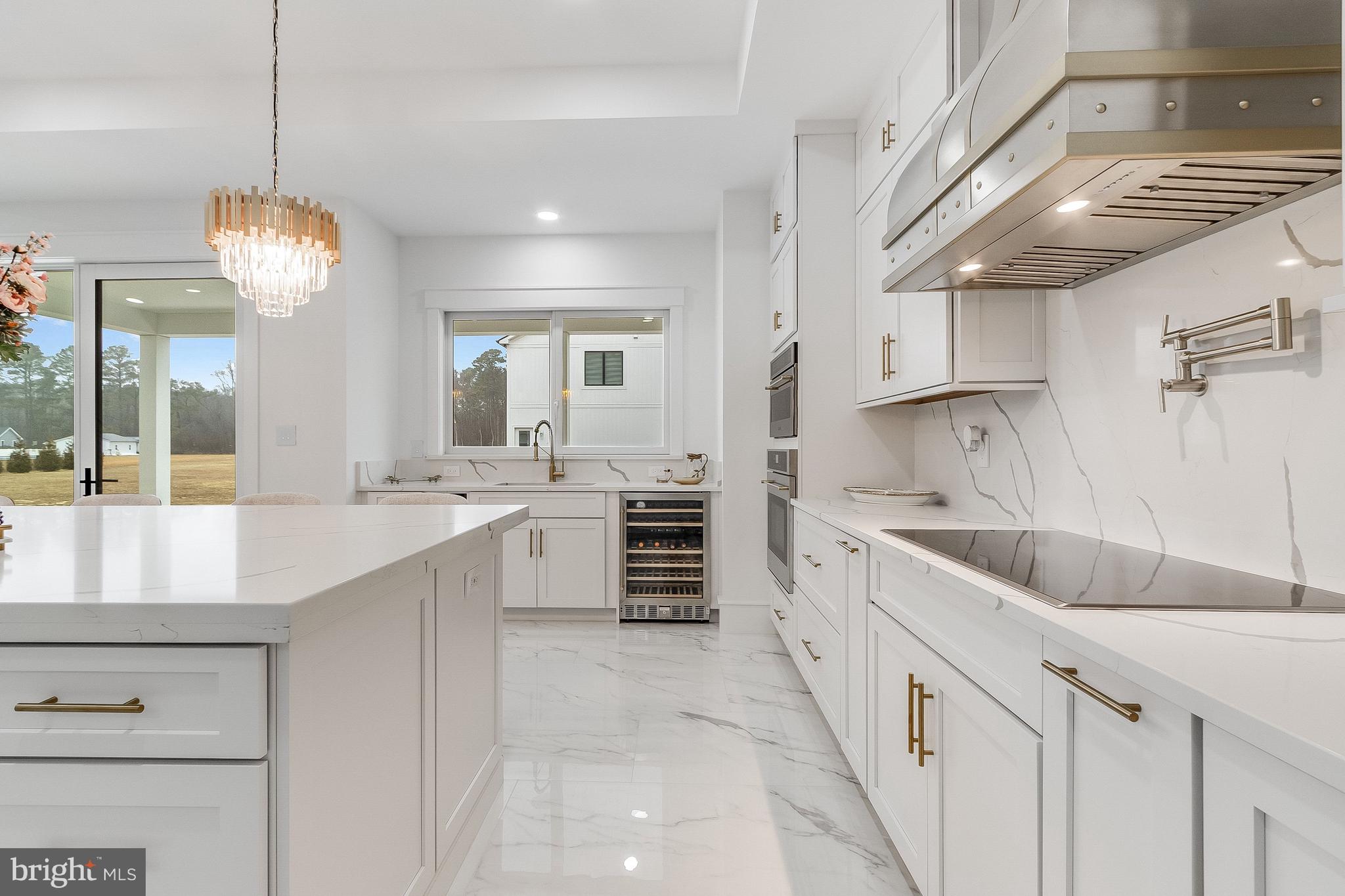 20157 West Piney Grove Road Georgetown, DE 19947 - Photo 11 of 104 a large kitchen with kitchen island a large counter space a sink stainless steel appliances and cabinets