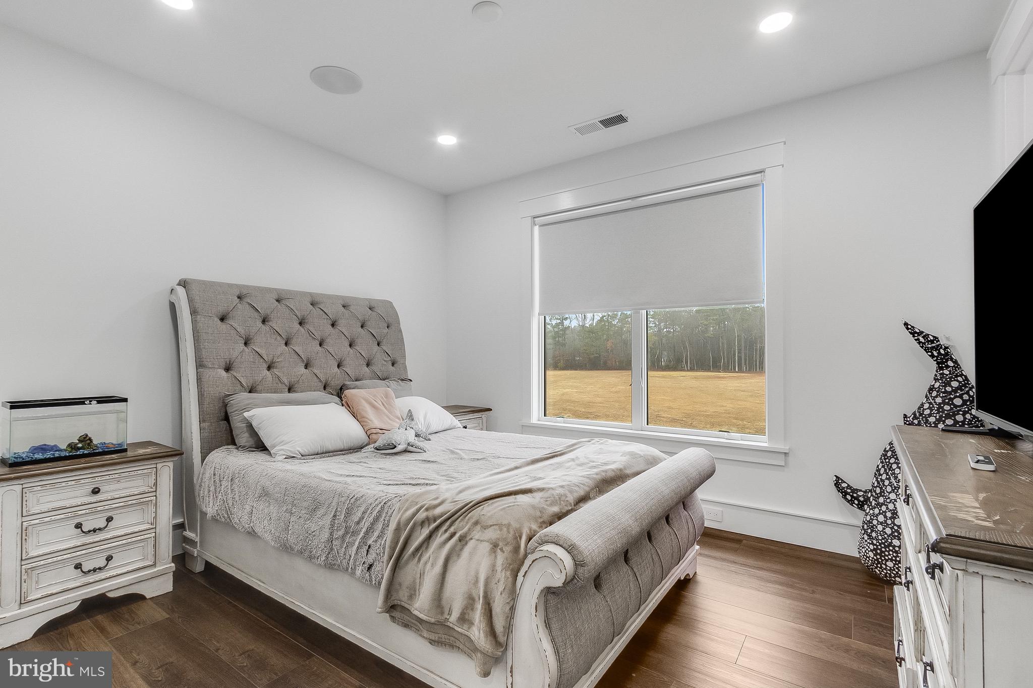 20157 West Piney Grove Road Georgetown, DE 19947 - Photo 71 of 104 a bedroom with a bed and a flat tv screen on the dresser