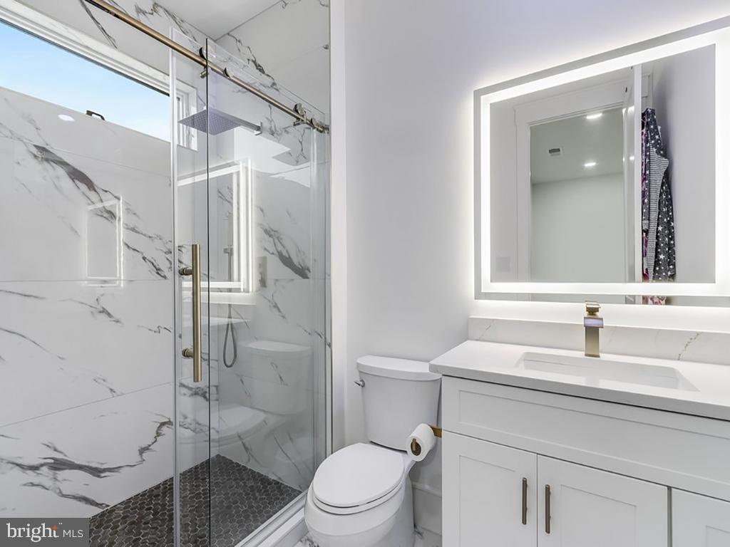20157 West Piney Grove Road Georgetown, DE 19947 - Photo 73 of 104 a bathroom with a sink toilet vanity and shower