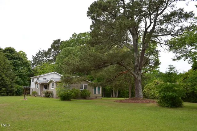 a front view of a house with a yard and trees