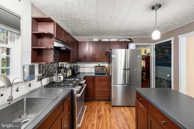 a kitchen with stainless steel appliances granite countertop a sink refrigerator and cabinets