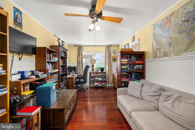 a living room with furniture cabinets and a large window