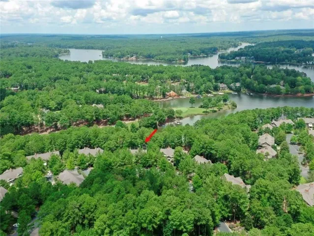 an aerial view of residential houses with outdoor space and trees