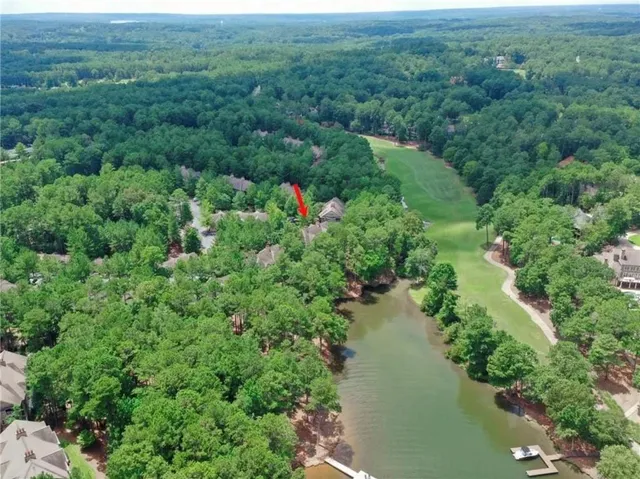 an aerial view of residential house with outdoor space and trees all around