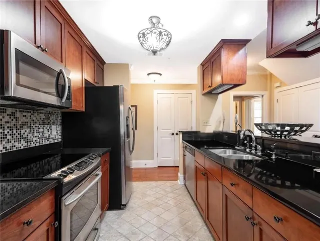 a kitchen with stainless steel appliances granite countertop a stove a sink and a microwave