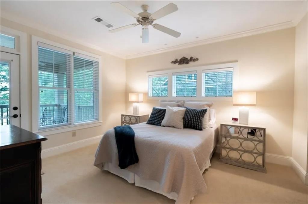 1060 Tailwater, Unit F Greensboro, GA 30642 - Photo 8 of 24 a bedroom with a large bed and a chandelier fan