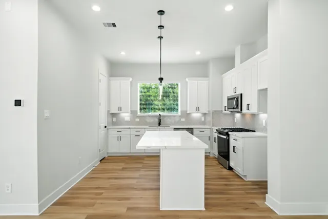 a kitchen with stainless steel appliances granite countertop a sink stove and refrigerator
