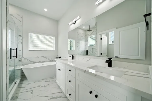 a bathroom with a double vanity sink mirror and bathtub