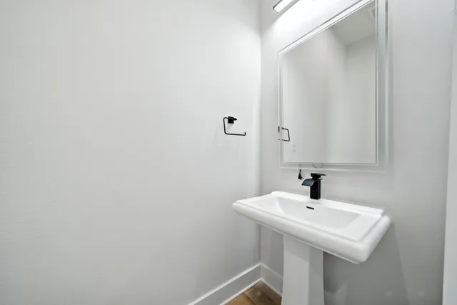 a white sink sitting under a bathroom mirror