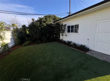 a white house that has tree in front of it