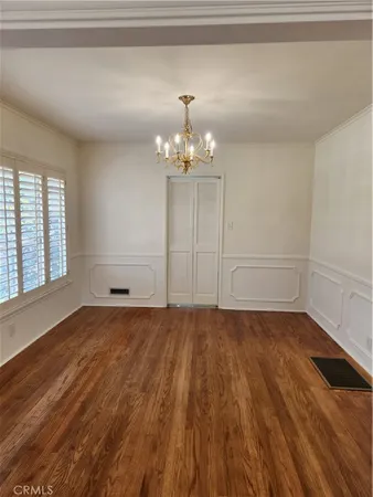 a view of a room with wooden floors and chandelier
