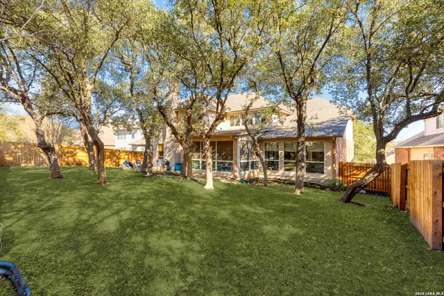 a view of a house with a big yard and large trees