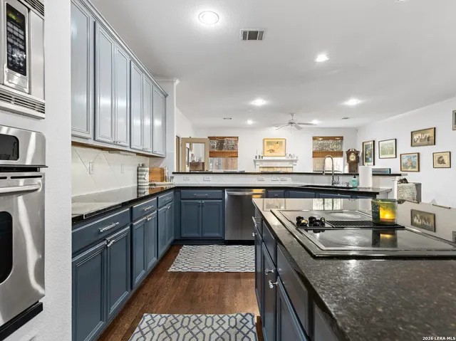 a kitchen with stainless steel appliances granite countertop a stove sink and cabinets