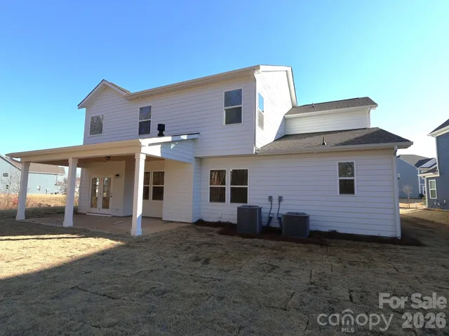 a view of a house with a yard and wooden fence