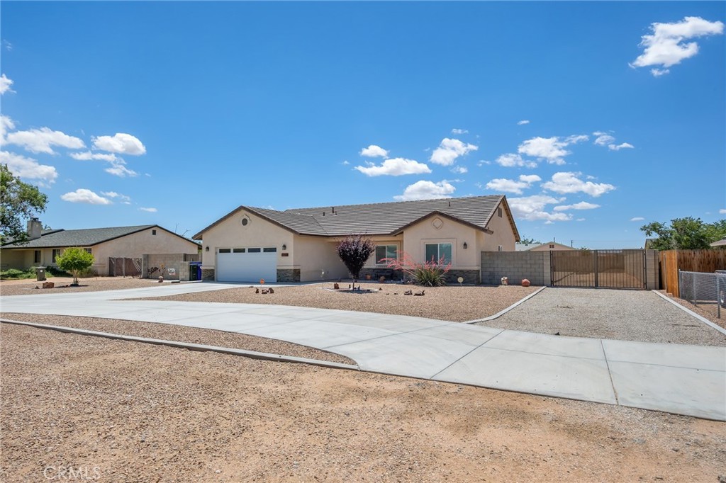 13178 Setancket Road Apple Valley, CA 92308 - Photo 2 of 24 a front view of a house with a yard and garage