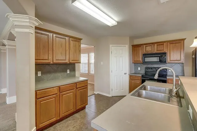 a kitchen with stainless steel appliances granite countertop a refrigerator a stove top oven a sink and dishwasher