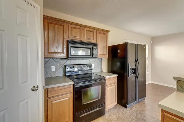 a kitchen with stainless steel appliances granite countertop a refrigerator stove and microwave