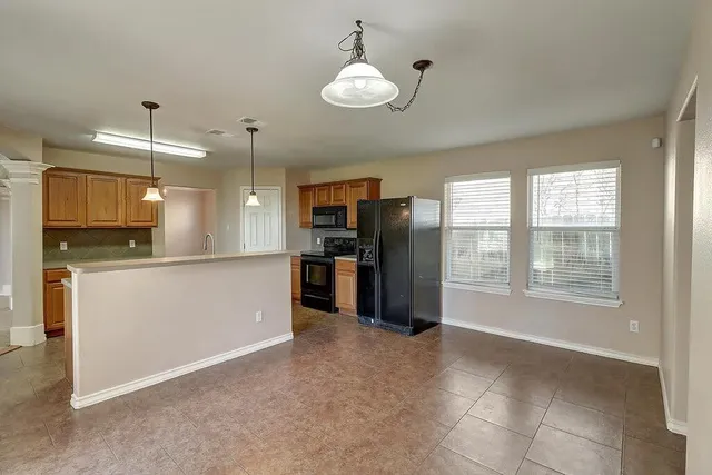 a view of a kitchen with refrigerator and windows