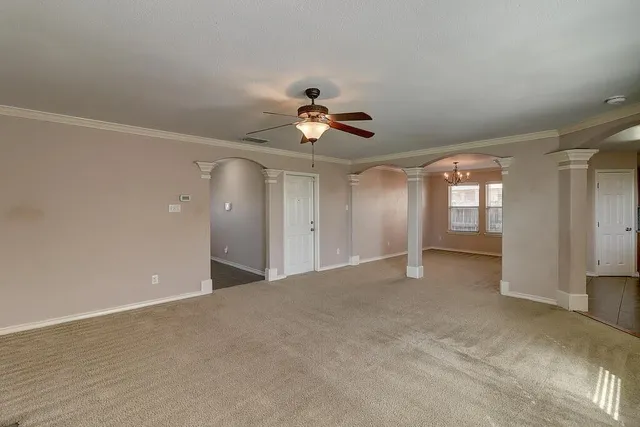 a view of a room with chandelier fan and windows