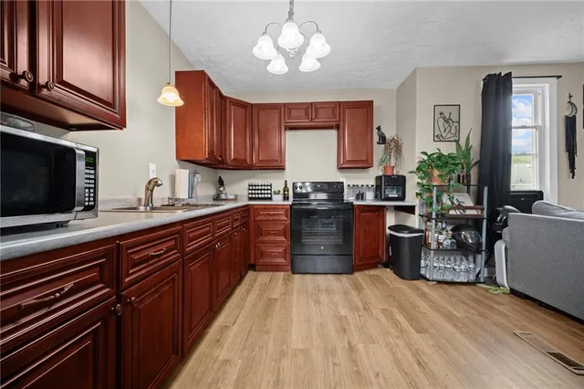 a kitchen with stainless steel appliances kitchen island granite countertop wooden cabinets a stove a sink and dishwasher
