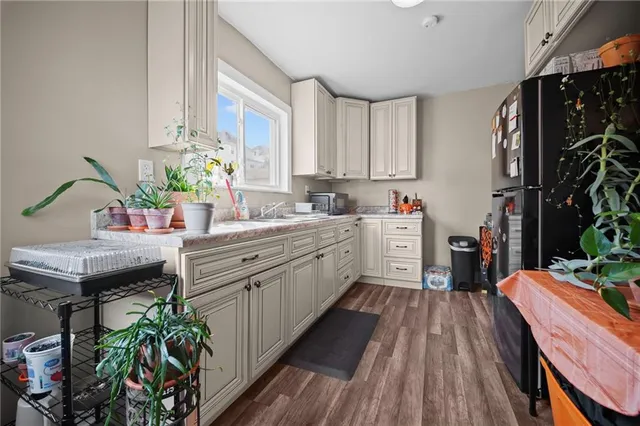 a kitchen that has a lot of cabinets a sink and wooden floor