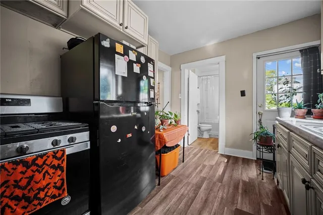 a kitchen with stainless steel appliances granite countertop a stove a refrigerator and a wooden cabinets