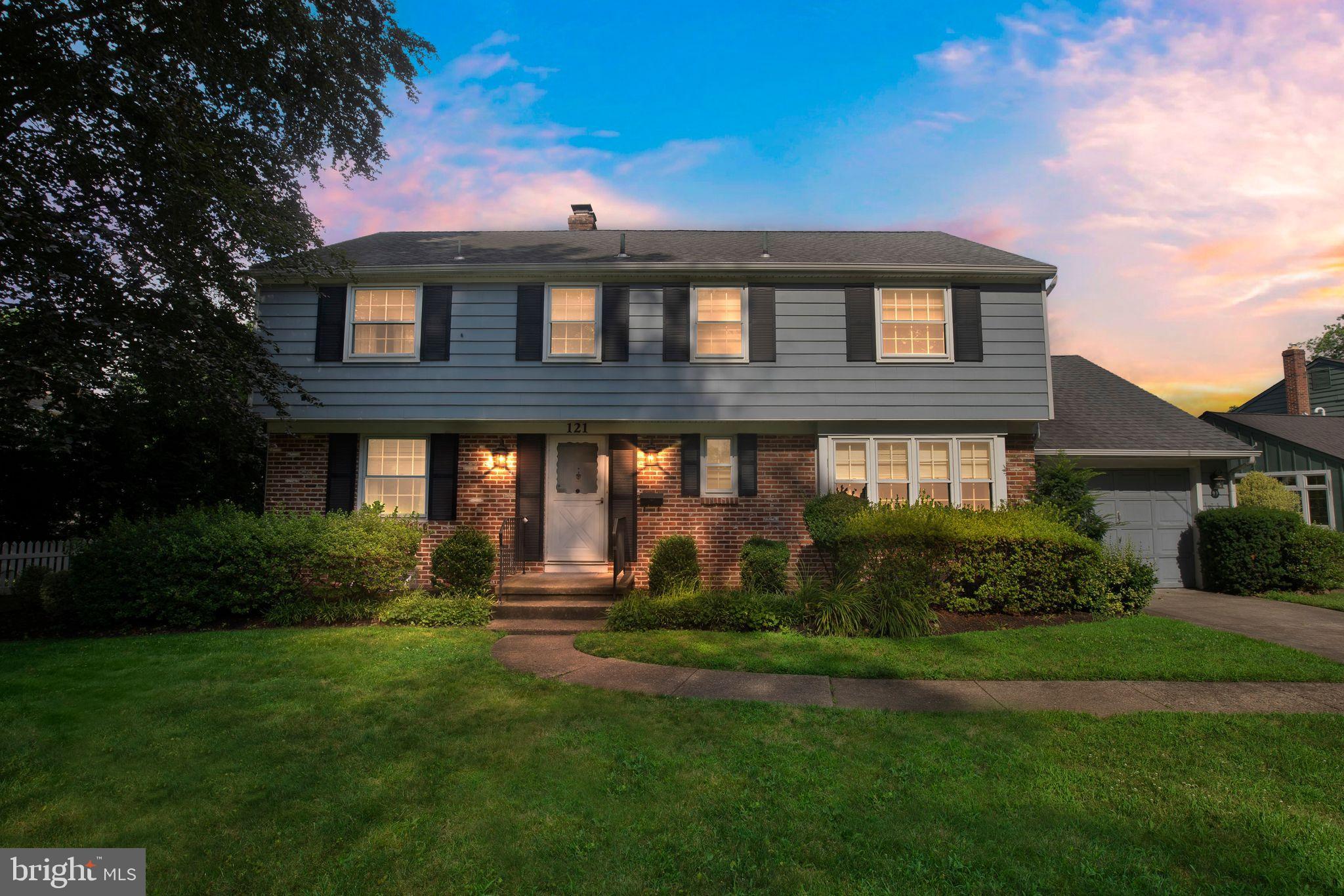 a front view of a house with a yard and potted plants