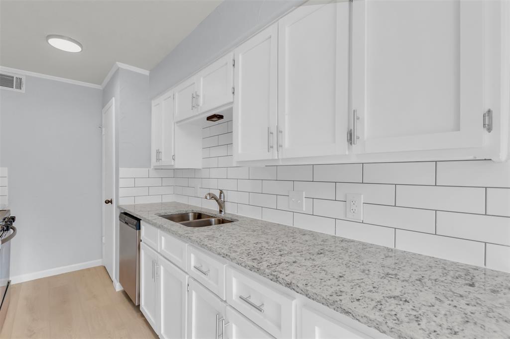 7610 Highmont Street Dallas, TX 75230 - Photo 13 of 37 a kitchen with granite countertop white cabinets and a sink
