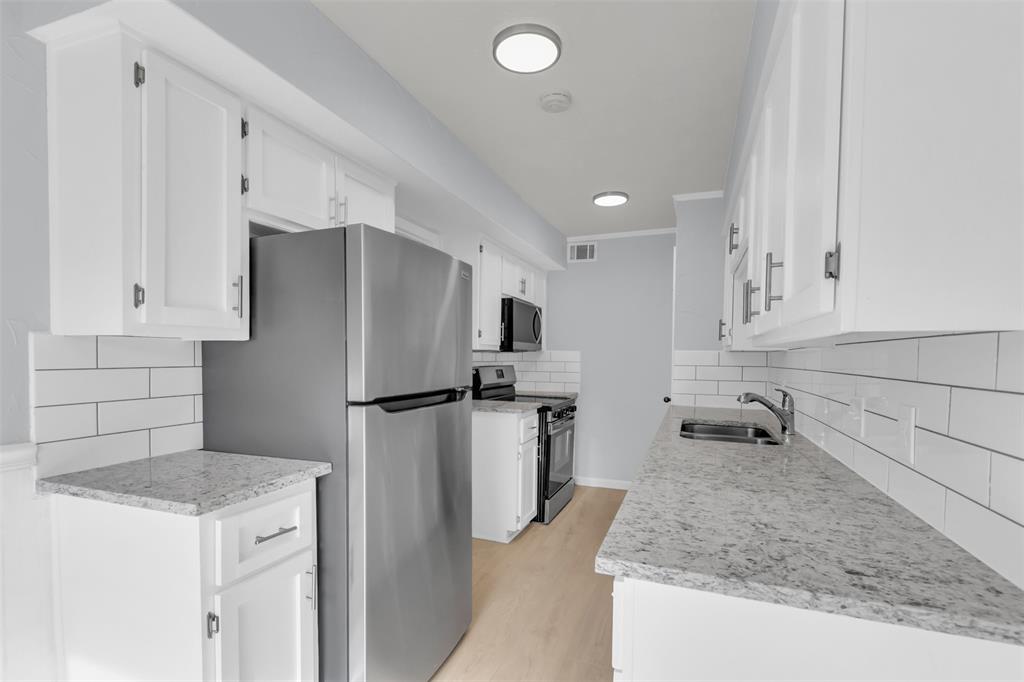 7610 Highmont Street Dallas, TX 75230 - Photo 14 of 37 a kitchen with a refrigerator a sink and dishwasher