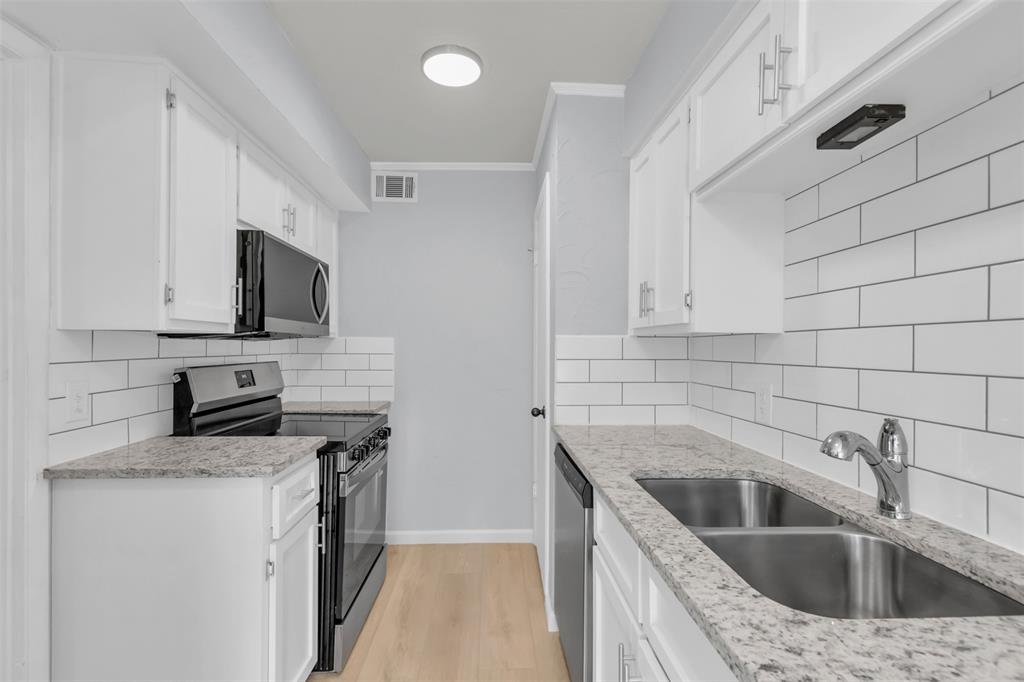 7610 Highmont Street Dallas, TX 75230 - Photo 15 of 37 a kitchen that has a sink and a stove