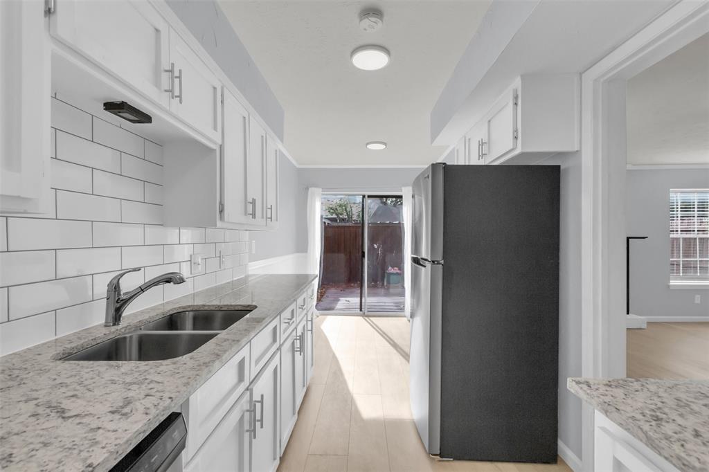 7610 Highmont Street Dallas, TX 75230 - Photo 16 of 37 a kitchen with a sink a refrigerator and cabinets