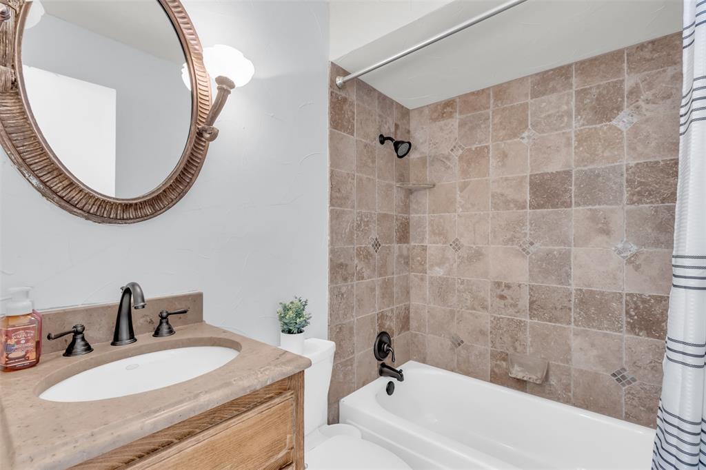 7610 Highmont Street Dallas, TX 75230 - Photo 25 of 37 a bathroom with a sink and a mirror