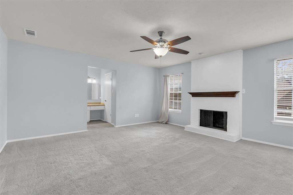 7610 Highmont Street Dallas, TX 75230 - Photo 28 of 37 a view of a livingroom with a fireplace a ceiling fan and window