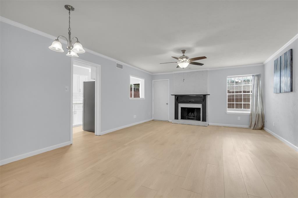 7610 Highmont Street Dallas, TX 75230 - Photo 6 of 37 a view of a livingroom with a ceiling fan a fireplace