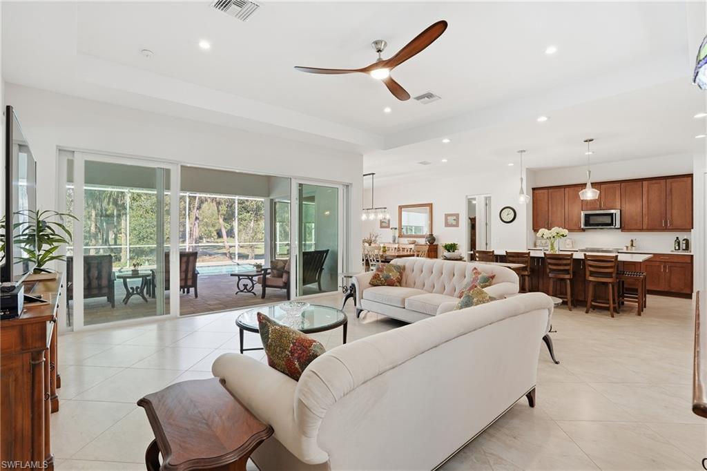3707 5th Avenue Southwest Naples, FL 34117 - Photo 13 of 45 Living room with ceiling fan, recessed lighting, light tile patterned flooring, a tray ceiling, and a sunroom